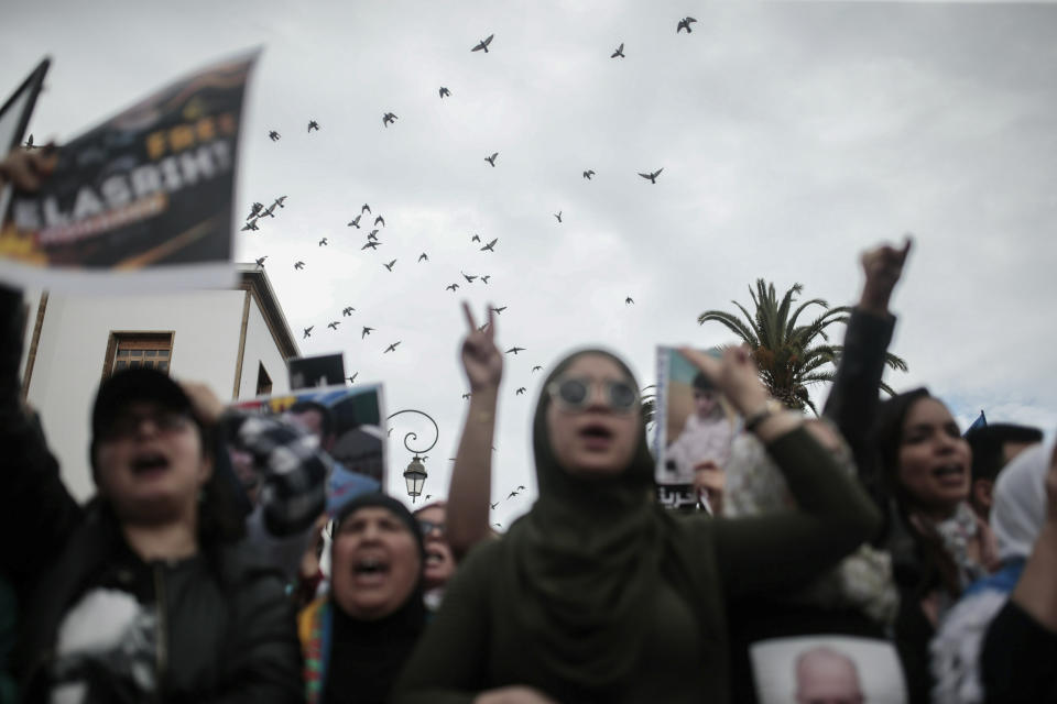 Birds fly as Moroccans gesture and chant slogans during a demonstration in Rabat, Morocco, Sunday, April 21, 2019. Protesters are condemning prison terms for the leader of the Hirak Rif protest movement against poverty and dozens of other activists. (AP Photo/Mosa'ab Elshamy)