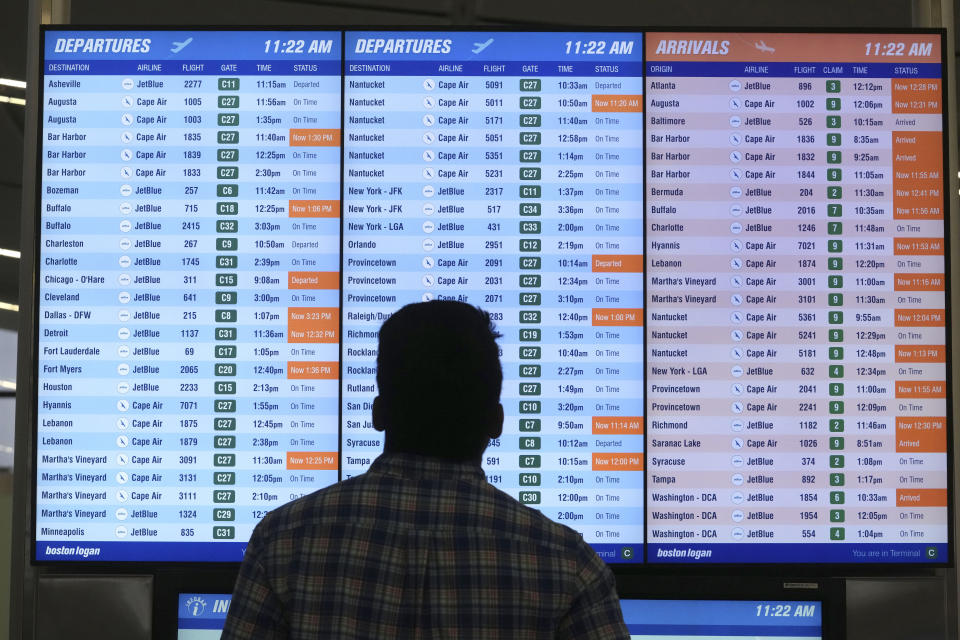 A man views a flight board at Boston Logan International Airport, Wednesday, June 28, 2023, in Boston. Travelers are getting hit with delays at U.S. airports again early Wednesday, an ominous sign heading into the long July 4 holiday weekend. (AP Photo/Steven Senne)