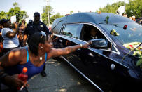 A woman tries to touch the hearse carrying the remains of late boxing champion Muhammad Ali as it passes along a street of Ali's childhood neighborhood. REUTERS/Carlos Barria