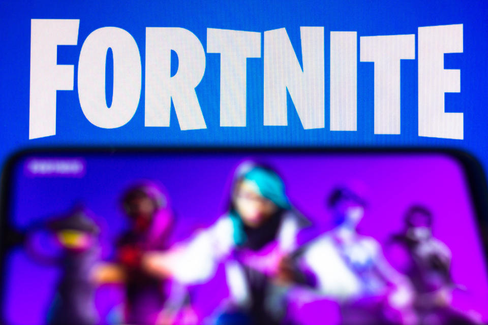 Illustration the Fortnite logo is seen on a smartphone and a pc screen