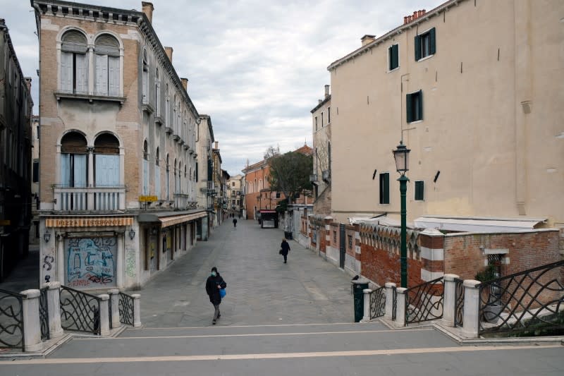 People walk in an almost empty Venice after Italy tightened the lockdown measures to combat the coronavirus disease (COVID-19) outbreak in Venice