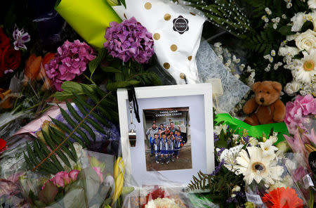 A picture is seen among the flower tribute at a memorial site for victims of the mosque shootings, at the Botanic Gardens in Christchurch, New Zealand, March 18, 2019. REUTERS/Edgar Su