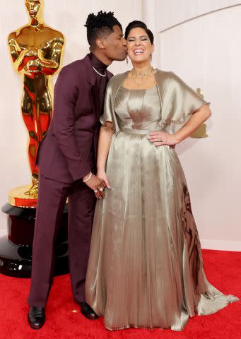 <p>Mike Coppola/Getty</p> Jon Batiste kissed Suleika Jaouad on the cheek at the 2024 Oscars