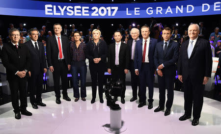 Candidates pose prior to a prime-time televised debate for the French 2017 presidential election in La Plaine Saint-Denis, near Paris, France. L to R: Jean-Luc Melenchon of the Parti de Gauche, Francois Fillon of the Republicans party, Jean Lassalle, Nathalie Arthaud of France's extreme-left Lutte Ouvriere party (LO), Marine Le Pen of French National Front (FN), Benoit Hamon of the French Socialist party, Jacques Cheminade, Nicolas Dupont-Aignan of Debout La France group, Emmanuel Macron of the political movement En Marche ! (Onwards !), Francois Asselineau of UPR party. REUTERS/Lionel Bonaventure/Pool