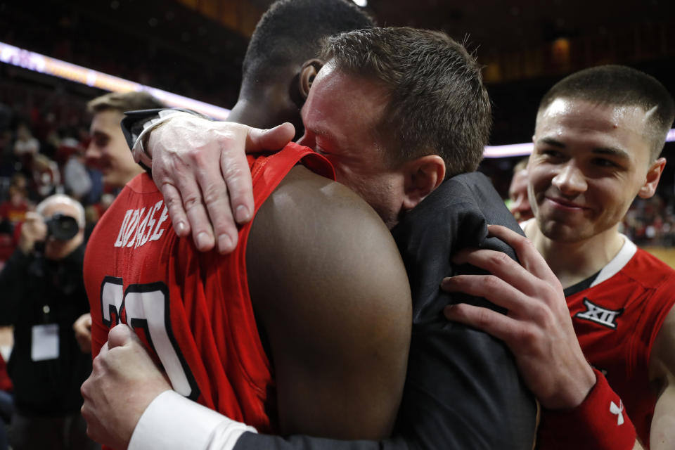 Texas Tech head coach Chris Beard, center, gets a hug from center Norense Odiase, left, after an NCAA college basketball game against Iowa State, Saturday, March 9, 2019, in Ames, Iowa. Texas Tech won 80-73. (AP Photo/Charlie Neibergall)