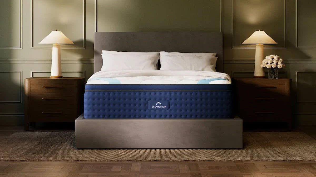  Image shows the DreamCloud Premier Hybrid Mattress which we reviewed on a tall grey fabric bed frame in . 