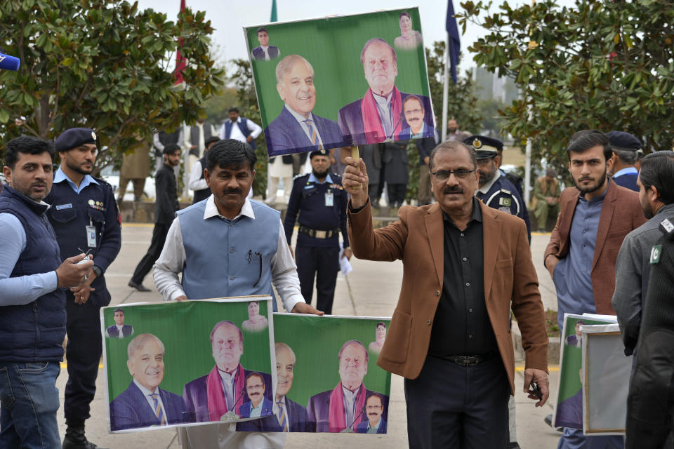 Darshan Punchi, second right, Pakistan's newly elected lawmaker from Pakistan Muslim League-N party holds a poster of their leaders Nawaz Sharif and Shahbaz Shrif, as he arrives to attend the opening session of parliament, in Islamabad, Pakistan, Thursday, Feb. 29, 2024. Pakistan's National Assembly swore in newly elected members on Thursday in a chaotic scene, as allies of jailed former Premier Khan protested what they claim was a rigged election. (AP Photo/Anjum Naveed)