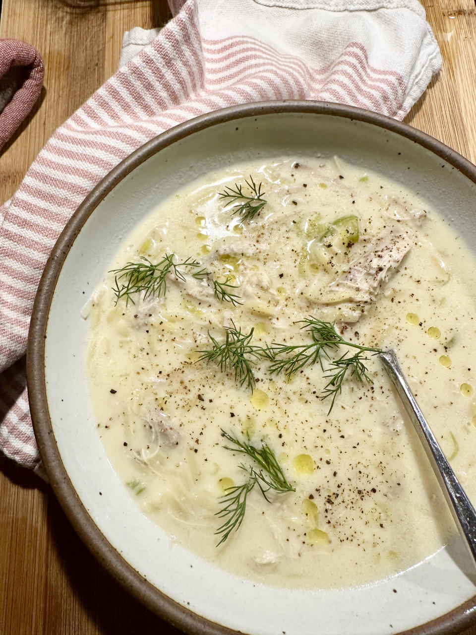 A bowl of creamy soup garnished with fresh dill