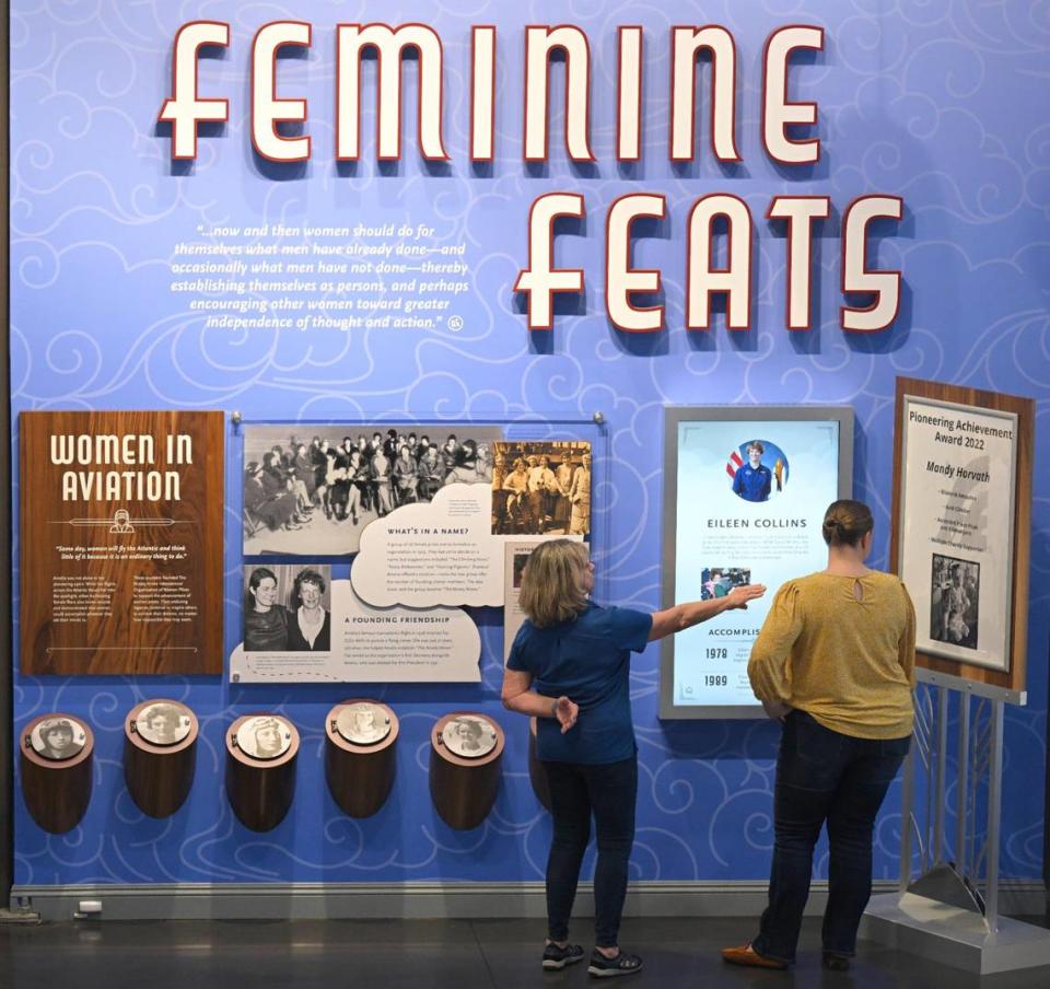 Karen Seaberg, the founder and president of the Atchison Amelia Earhart Foundation, and Makinzie Burghart, director of operations, look over the Feminine Feats exhibit at the new Amelia Earhart Hangar Museum.