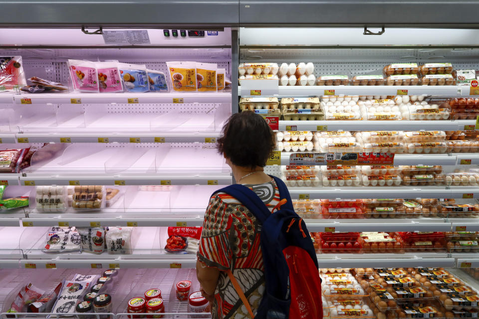 A shopper looks at near empty shelves at a supermarket as super typhoon Saola approaches Hong Kong on Friday, Sept. 1, 2023. Most of Hong Kong and parts of southern China ground to a near standstill as Super Typhoon Saola edged closer Friday. (AP Photo/Daniel Ceng)