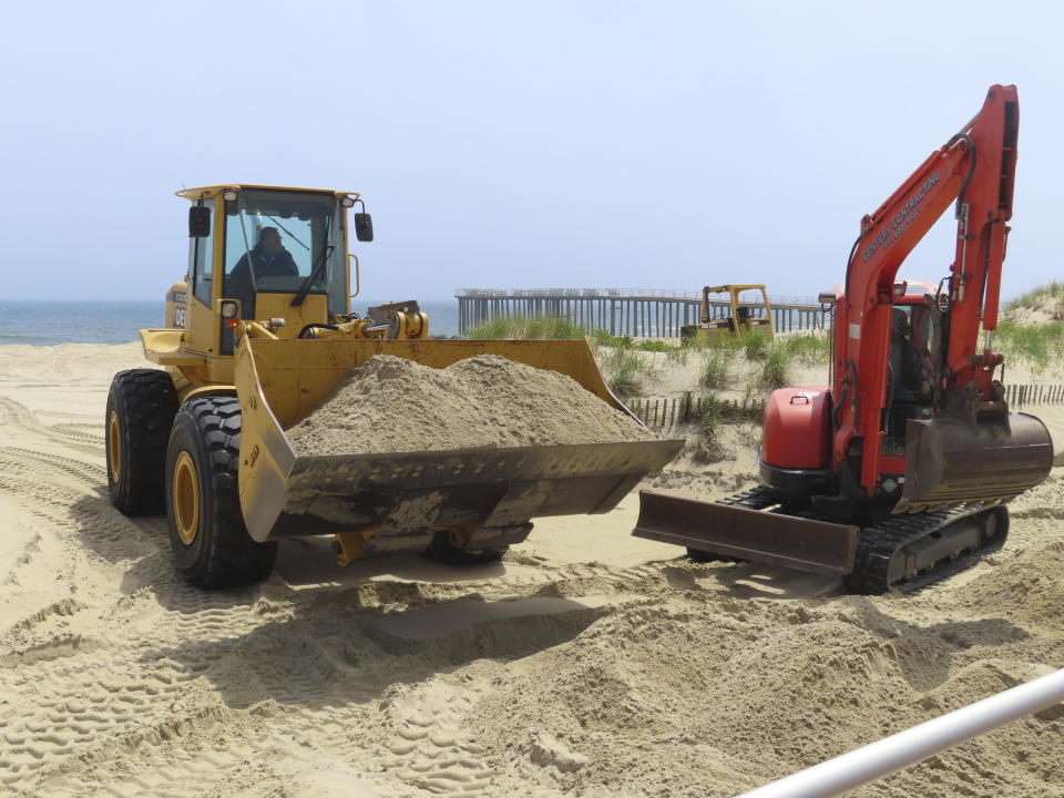 Workers use heavy equipment to move sand on the Ocean Grove, N.J. boardwalk on May 2, 2024 to prepare for the upcoming summer season. The state of New Jersey says the Ocean Grove Camp Meeting Association is violating state beach access laws by keeping people off the beach until noon on Sundays. (AP Photo/Wayne Parry)