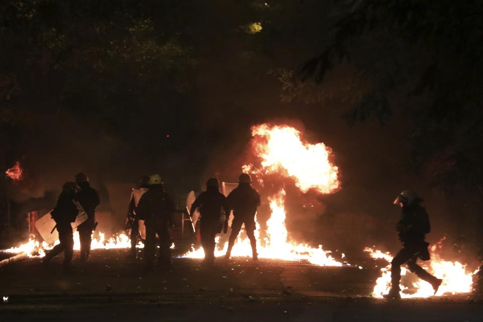 Riot policemen try to avoid petrol bombs during clashes outside the Polytechnic University in Athens, Saturday, Nov. 17, 2018. Greek police say clashes have broken out between police and anarchists in Athens and Thessaloniki on the 45th anniversary of a student uprising against Greece's then-ruling military regime. (AP Photo/Yorgos Karahalis)