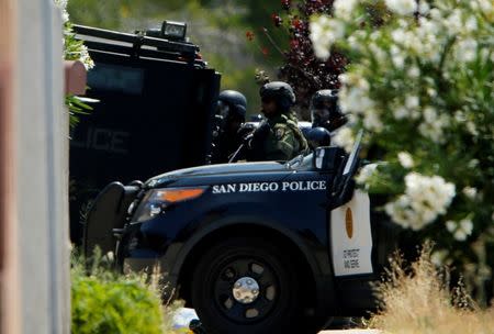 A police SWAT team positions themselves as they surround a home after a San Diego police officer was fatally shot and another was wounded late on Thursday, in San Diego, California, United States July 29, 2016. REUTERS/Mike Blake