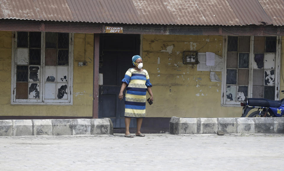 A woman wearing a face mask walks at the Yaba Mainland hospital where an Italian citizen who entered Nigeria on Tuesday from Milan on a business trip, the first case of the COVID-19 virus is being treated in Lagos Nigeria Friday, Feb. 28, 2020. Nigeria's health authorities have reported the country's first case of a new coronavirus in Lagos, the first confirmed appearance of the disease in sub-Saharan Africa. (AP Photo/ Sunday Alamba)