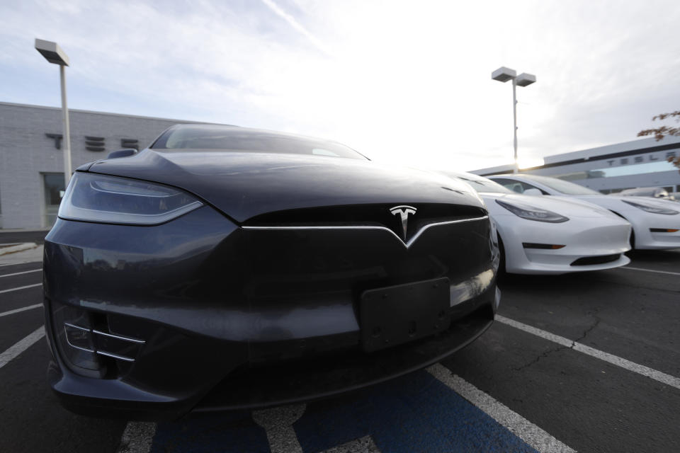 FILE - In this Nov. 10, 2019, file photo an unsold Model X sports-utility vehicle sits with other vehicles at a Tesla dealership in Littleton, Colo. Shares of Tesla Inc. continued their wild run Wednesday, Jan. 22, 2020, rising another 6.3% and pushing the electric car and solar panel maker's market value above $100 billion. (AP Photo/David Zalubowski, File)