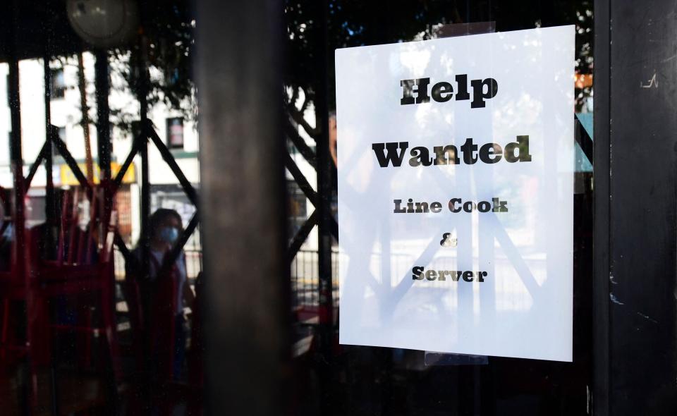 Pedestrians walk past a "Help Wanted" sign posted at restaurant looking for line cooks and servers on June 22, 2021 in Los Angeles, California. - Restaurant owners in California are facing a labour crisis amid the Covid reopening, unable to find enough workers, while across the country The National Restaurant Association has reported some 2.5 million jobs were lost in the eating and drinking industry in 2020. (Photo by Frederic J. BROWN / AFP) (Photo by FREDERIC J. BROWN/AFP via Getty Images)
