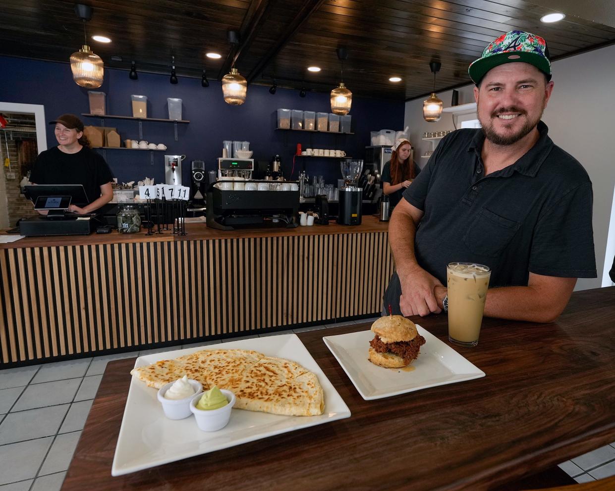 Clay Cass and his wife Michelle Cass, behind register, recently opened Trilogy Kitchen at 844 E. New York Ave. in DeLand. In addition to selling their Trilogy Coffee Roasting Co. drinks, their new business offers breakfast and lunch items like chicken biscuits and quesadillas.