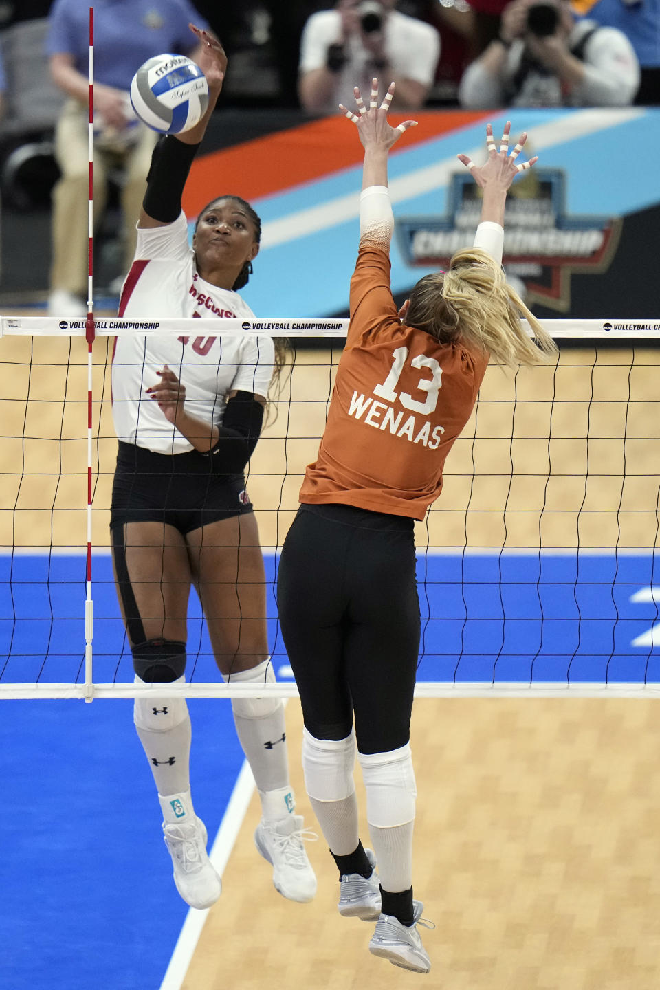 Wisconsin's Devyn Robinson (10) scores over Texas's Jenna Wenaas (13) during a semifinal match in the NCAA Division I women's college volleyball tournament Thursday, Dec. 14, 2023, in Tampa, Fla. (AP Photo/Chris O'Meara)