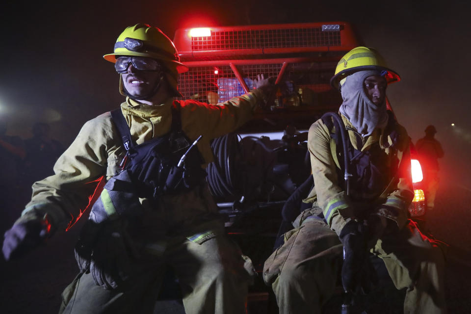 Dos bomberos están sentados en un vehículo en medio de incendios en Córdoba, Argentina, el lunes 12 de octubre de 2020. (AP Foto/Nicolas Aguilera)