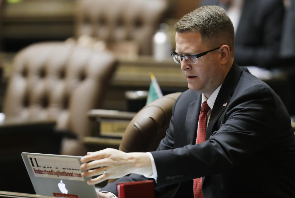 Washington State Rep. Matt Shea, R-Spokane Valley, adjusts his laptop computer on the floor of the House, Monday, April 22, 2019, at the Capitol in Olympia, Wash. Gov. Jay Inslee and other Democrats in Washington state are a criticizing Shea for appearing to support spying on political opponents, after The Guardian newspaper reported Saturday it had obtained the contents of messaging chats involving Shea and three other men discussing the topic. (AP Photo/Ted S. Warren)