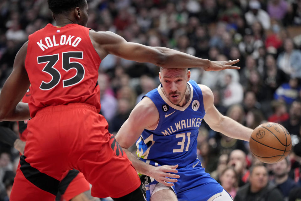 Milwaukee Bucks guard Goran Dragic (31) looks for a way around Toronto Raptors centre Christian Koloko (35) during first half of an NBA basketball game in Toronto, Sunday, April 9, 2023. (Frank Gunn/The Canadian Press via AP)