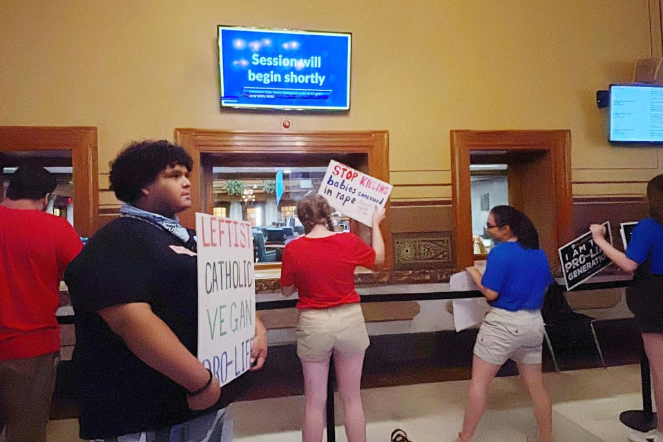 Anti-abortion protesters sing "Amazing Grace" outside the Indiana Senate chamber Thursday, July 28, 2022, in Indianapolis. The demonstrators were awaiting the start of debate on a Republican-sponsored abortion ban bill as GOP senators met privately amid days of public division over how tightly the law should cover any exceptions for rape or incest victims. (AP Photo/Arleigh Rodgers)