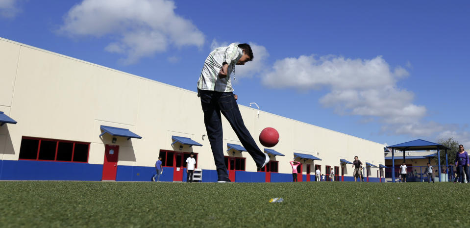 Fotografía de archivo del 10 de septiembre de 2014 de niños inmigrantes detenidos jugando a la pelota en el centro residencial del condado Karnes, para la detención de familias migrantes, en Karnes City, Texas. (AP Foto/Eric Gay, Archivo)