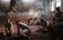 Wrestlers practise as others rest in the mud at a traditional Indian wrestling centre called Akhaara in Mumbai in this March 4, 2014 file photo. REUTERS/Danish Siddiqui/Files (INDIA - Tags: SOCIETY SPORT TPX IMAGES OF THE DAY)