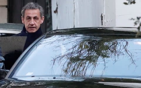 Sarkozy enters his car as he leaves his house in Paris on Wednesday - Credit: BENOIT TESSIER/REUTERS