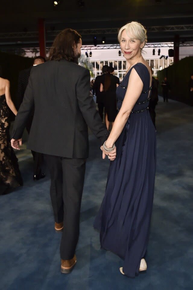 Grant wore a plunging, navy blue gown, as she was snapped adoringly gazing at Reeves in his black suit.