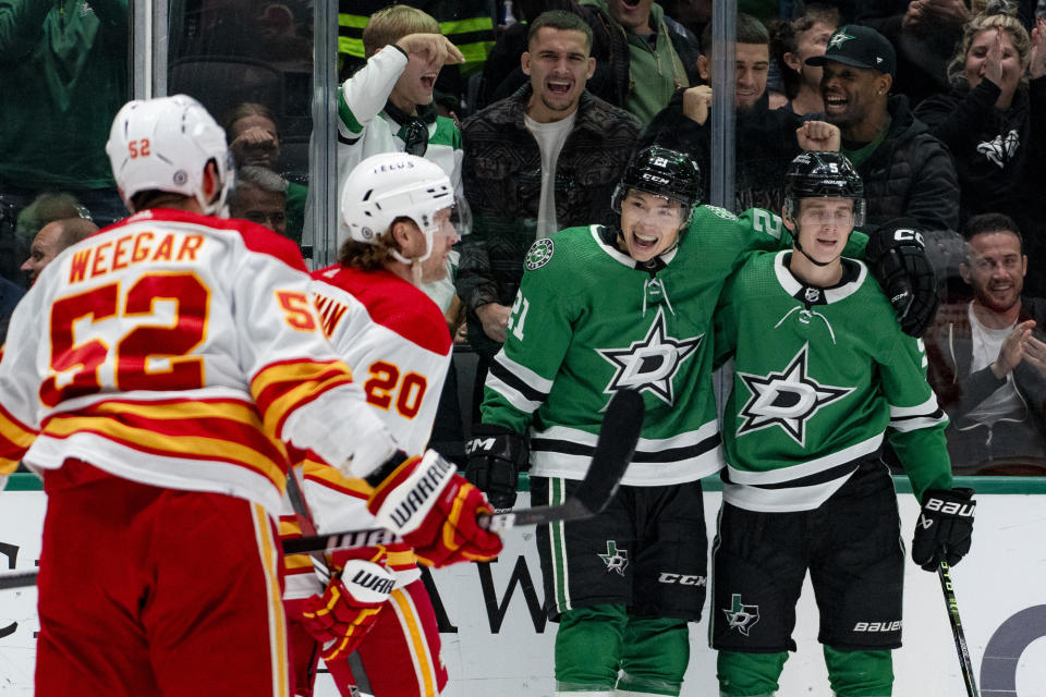 Dallas Stars left wing Jason Robertson (21) smiles as he embraces defenseman Nils Lundkvist, right, after scoring during the first period of an NHL hockey game against the Calgary Flames, Friday, Nov. 24, 2023, in Dallas. (AP Photo/Emil T. Lippe)