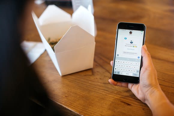 The Venmo app displayed on a smartphone, with an open Chinese food container in the background.