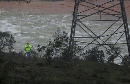 A survey crew walks near the base of the Lake Oroville Dam after an evacuation order was lifted for communities downstream in Oroville, California, U.S. February 15, 2017. REUTERS/Jim Urquhart