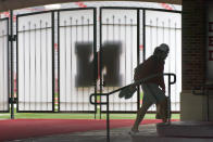 A player carries his shoes and a lunch bag in front of a closed gate leading to Memorial Stadium's playing field in Lincoln, Neb., Wednesday, Aug. 12, 2020. The Big Ten won't play football this fall because of concerns about COVID-19, becoming the first of college sports' power conferences to yield to the pandemic. The move announced Tuesday. (AP Photo/Nati Harnik)