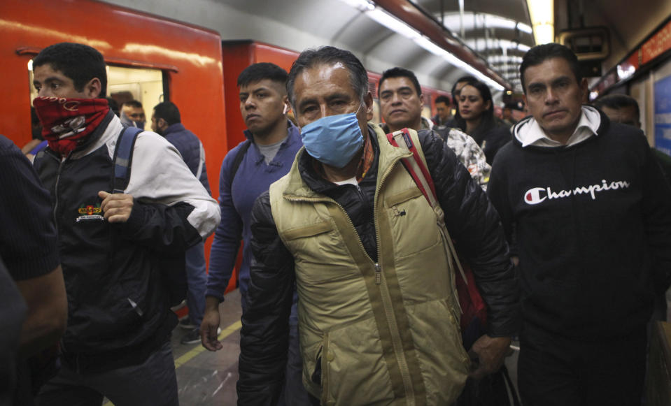 A commuter wears a protective mask as a precaution against the spread of the new coronavirus in the metro in Mexico City, Thursday, March 19, 2020. (AP Photo/Marco Ugarte)
