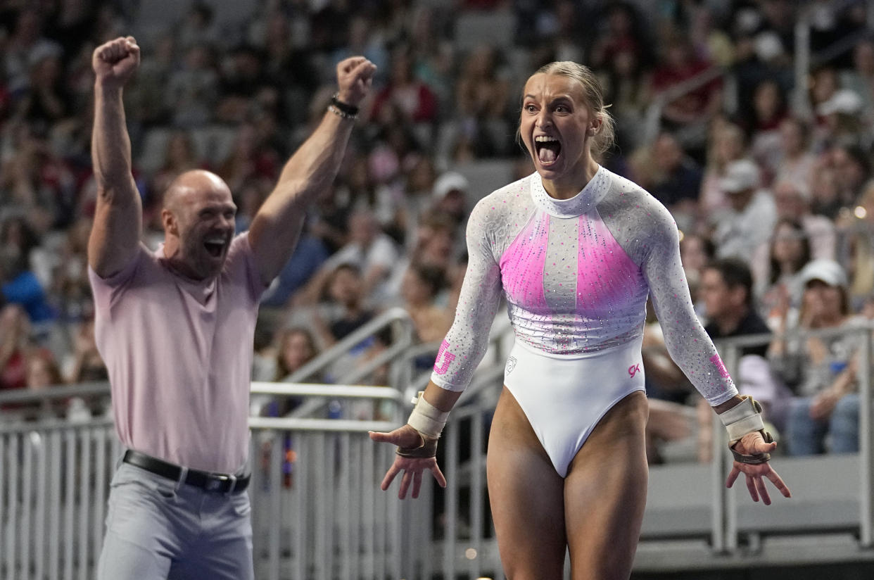 Utah's Abby Brenner and assistant coach Jimmy Pratt, left, celebrate after Brenner competed in the vault during the final of the NCAA women's gymnastics championships, Saturday, April 15, 2023, in Fort Worth, Texas. (AP Photo/Tony Gutierrez)