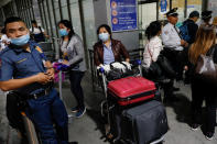 Overseas Filipino Workers (OFW) wearing protective masks standby outside the Ninoy Aquino International Airport in Pasay City, Metro Manila, Philippines, February 18, 2020. REUTERS/Eloisa Lopez