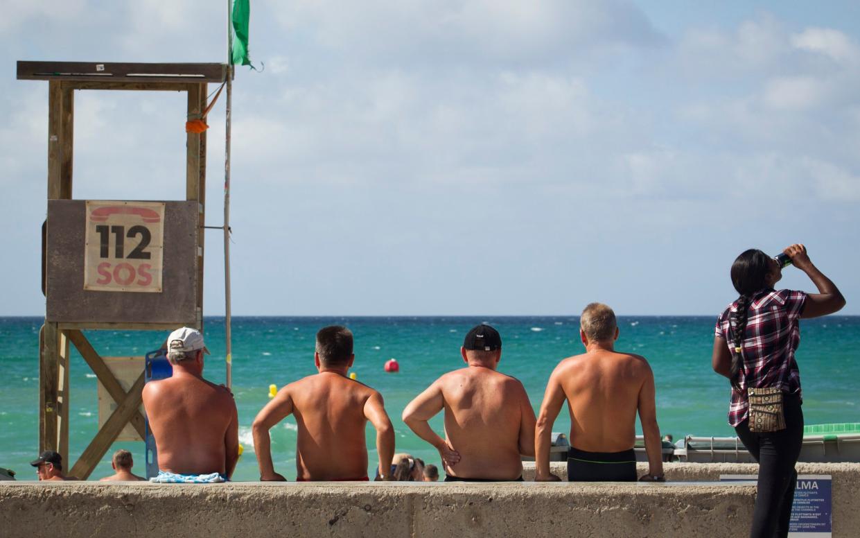 Tourists enjoy a sunny day at the Playa de Palma beach in Palma de Mallorca