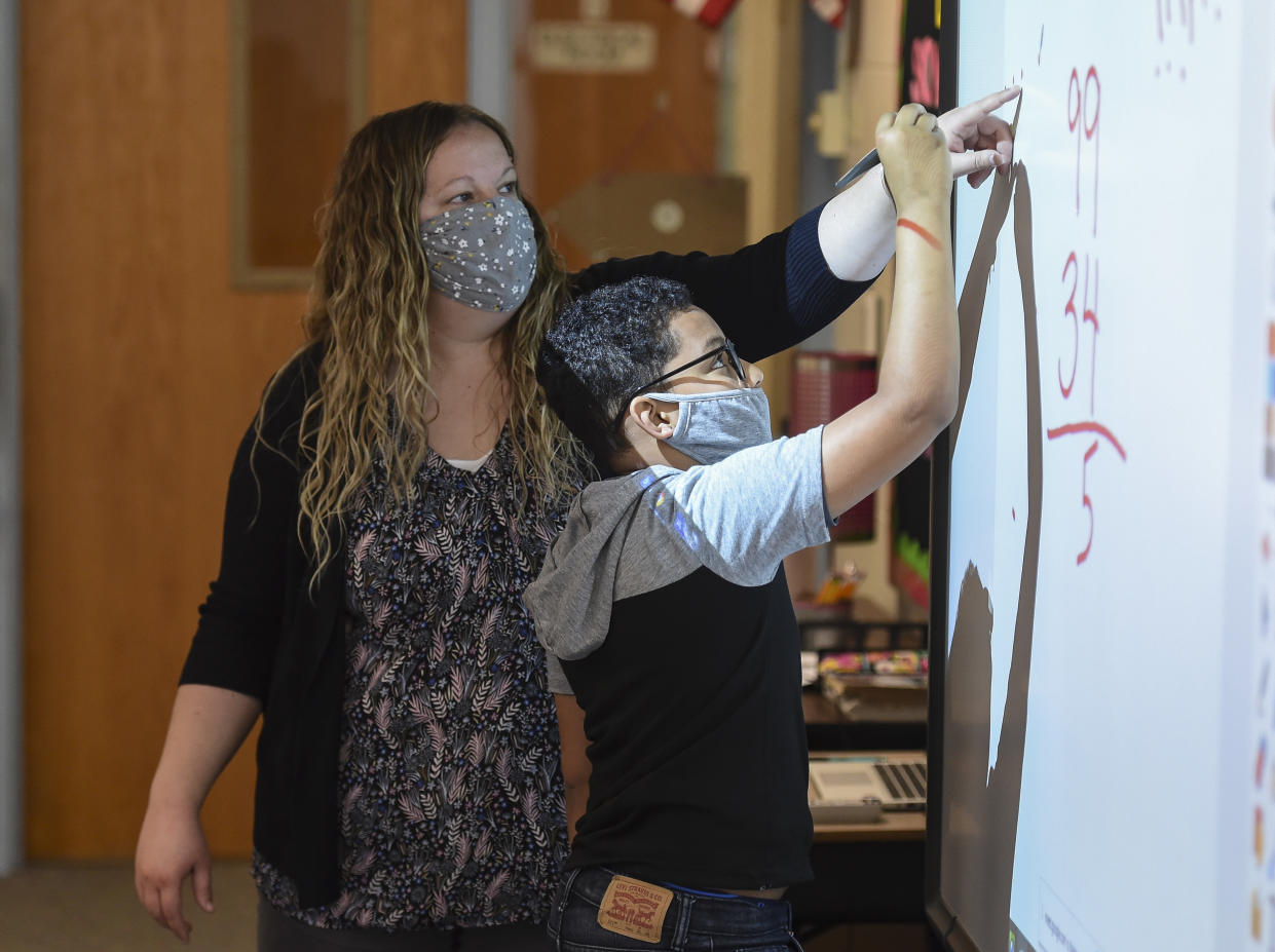 Cumru Twp, PA - April 14: Sabrina Werley works with 4th grade student Josh Ayala as he does a math problem at the board during a math support class. During class with Learning Support teacher Sabrina Werley at Cumru Elementary School in Cumru township Wednesday morning April 14, 2021. Werley is the 2021 recipient of the Annie Sullivan Award, which recognizes local educators for their service to students with special needs. (Photo by Ben Hasty/MediaNews Group/Reading Eagle via Getty Images)