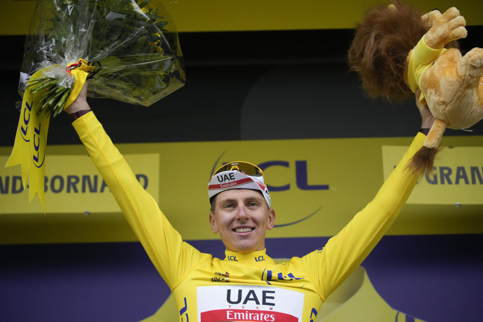 El nuevo líder general Tadej Pogacar celebra en el podio de la octava etapa del Tour de Francia, el sábado 3 de julio de 2021. (AP Foto/Christophe Ena)