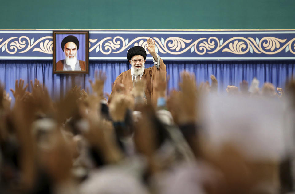 FILE - In this Nov. 27, 2019, file photo released by the official website of the office of the Iranian supreme leader, Supreme Leader Ayatollah Ali Khamenei waves to members of the Revolutionary Guard's all-volunteer Basij force in a meeting in Tehran, Iran. Khamenei on Wednesday, Dec. 4, 2019, reportedly called on judicial officials to treat those detained in recent nationwide protests with "Islamic mercy" after authorities acknowledged security forces shot and killed demonstrators nationwide. A portrait of the late revolutionary founder Ayatollah Khomeini hangs in background. (Office of the Iranian Supreme Leader via AP, File)