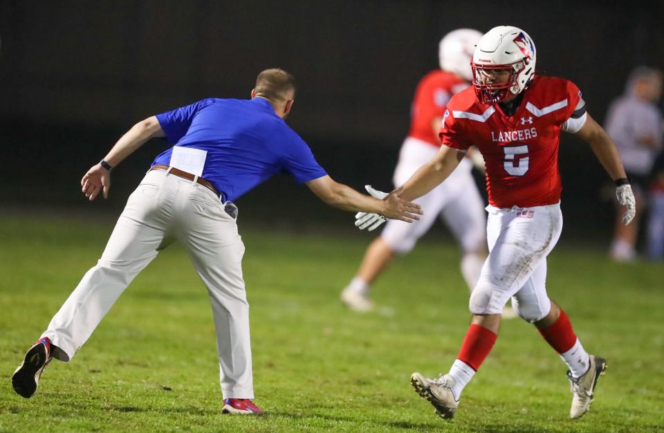 East Union head coach Mike Kuhnlenz congratulates running back David Flores (5) after an East Union score during a varsity football in Manteca.