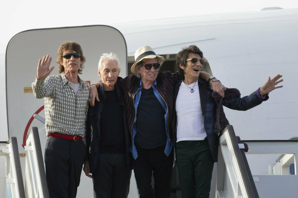 FILE - In this March 24, 2016 file photo, members of The Rolling Stones, from left, Mick Jagger, Charlie Watts, Keith Richards and Ron Wood pose for photos from the plane that brought them to Cuba at Jose Marti international airport in Havana, Cuba. The band plays Friday, June, 21, 2019 at Soldier Field in Chicago after a postponing their North American tour because frontman Mick Jagger needed medical treatment. A second show is scheduled for Tuesday at Soldier Field. (AP Photo/Ramon Espinosa File)
