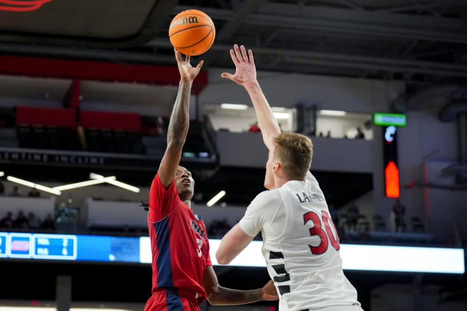 Nov 6, 2023; Cincinnati, Ohio, USA; Illinois-Chicago Flames guard CJ Jones (3) shoots against Cincinnati Bearcats forward Viktor Lakhin (30) in the second half at Fifth Third Arena. Mandatory Credit: Aaron Doster-USA TODAY Sports