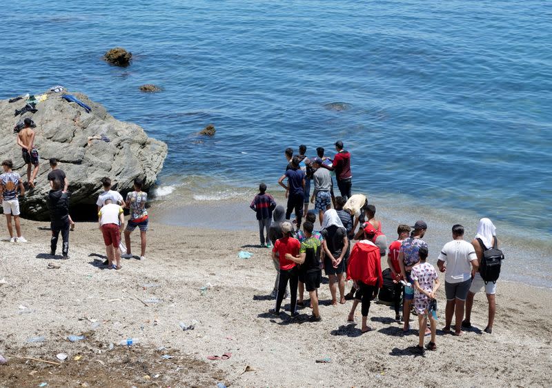 FILE PHOTO: Migrants stand on the beach in Fnideq, close to the Spanish enclave Ceuta