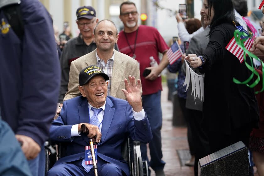 World War II veteran Joseph Eskenazi, who at 104 years and 11 months old is the oldest living veteran to survive the attack on Pearl Harbor, is greeted by staff as he arrives at the National World War II Museum to celebrate his upcoming 105th birthday in New Orleans, Wednesday, Jan. 11, 2023. (AP Photo/Gerald Herbert)