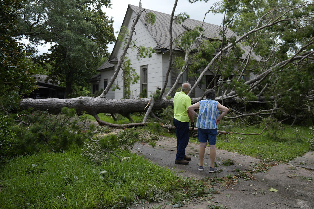 Jackie Jecmenek, right, talks with city worker Bobby Head as she stands in front of her neighbors home after Beryl passed, Monday, July 8, 2024, in Bay City, Texas. The National Hurricane Center said damaging winds and flash flooding will continue as Beryl continues pushing inland. (AP Photo/Eric Gay)