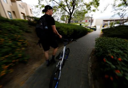 U.S. Olympic athlete Connor Fields walks his BMX bike to a training hill, at the Olympic Training Center in Chula Vista, California, United States, June 13, 2016. REUTERS/Mike Blake