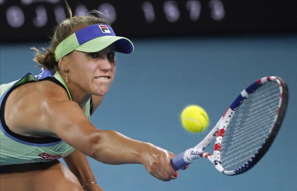 Sofia Kenin of the U.S. makes a backhand return to Spain's Garbine Muguruza during the women's final at the Australian Open tennis championship in Melbourne, Australia, Saturday, Feb. 1, 2020. (AP Photo/Lee Jin-man)