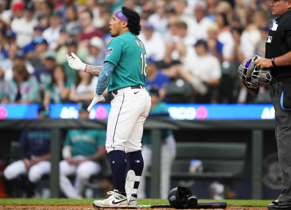 Seattle Mariners' Kolten Wong removes his batting gear after striking out swinging against the Detroit Tigers to end the third inning of a baseball game Saturday, July 15, 2023, in Seattle. (AP Photo/Lindsey Wasson)